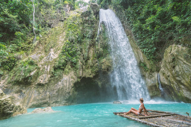 istock Girl contemplating beautiful waterfall 1124570670