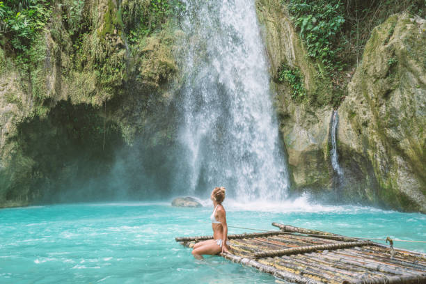 istock Girl contemplating beautiful waterfall 1124570701