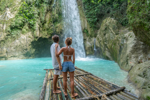 istock Young couple contemplating beautiful tropical waterfall 1124570867