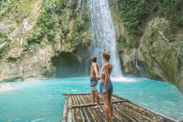 istock Young couple contemplating beautiful tropical waterfall 1124570965