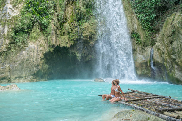 istock Young couple contemplating beautiful tropical waterfall 1124571573