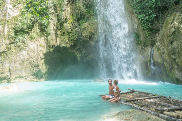istock Young couple contemplating beautiful tropical waterfall 1124571870