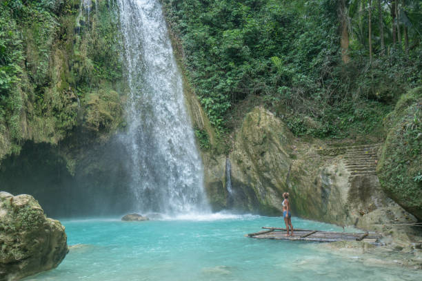 istock Girl contemplating beautiful waterfall 1124572204