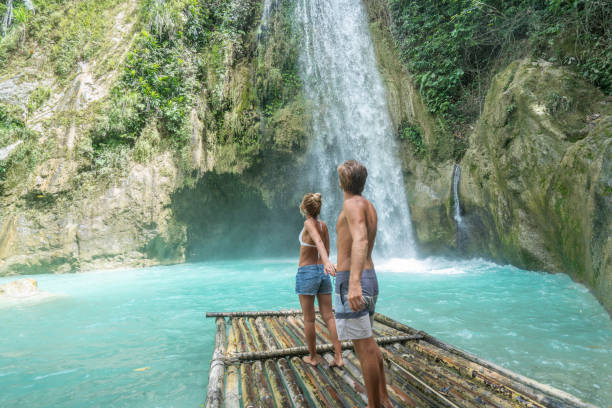 istock Young couple contemplating beautiful tropical waterfall 1124572770