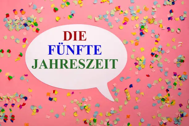 Paper Bubble Speech with german carnival greeting - Die fuenfte Jahreszeit - colorful confetti on pink cardboard