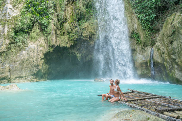 istock Young couple contemplating beautiful tropical waterfall 1124572826