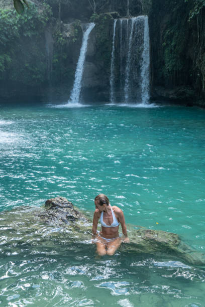istock Girl contemplating beautiful waterfall in the Philippines 1124573668