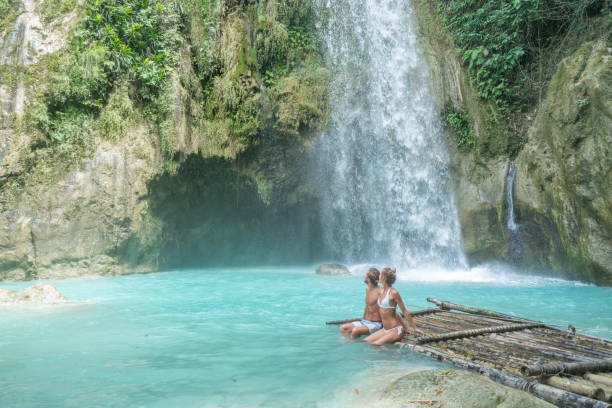 istock Young couple contemplating beautiful tropical waterfall 1124574690