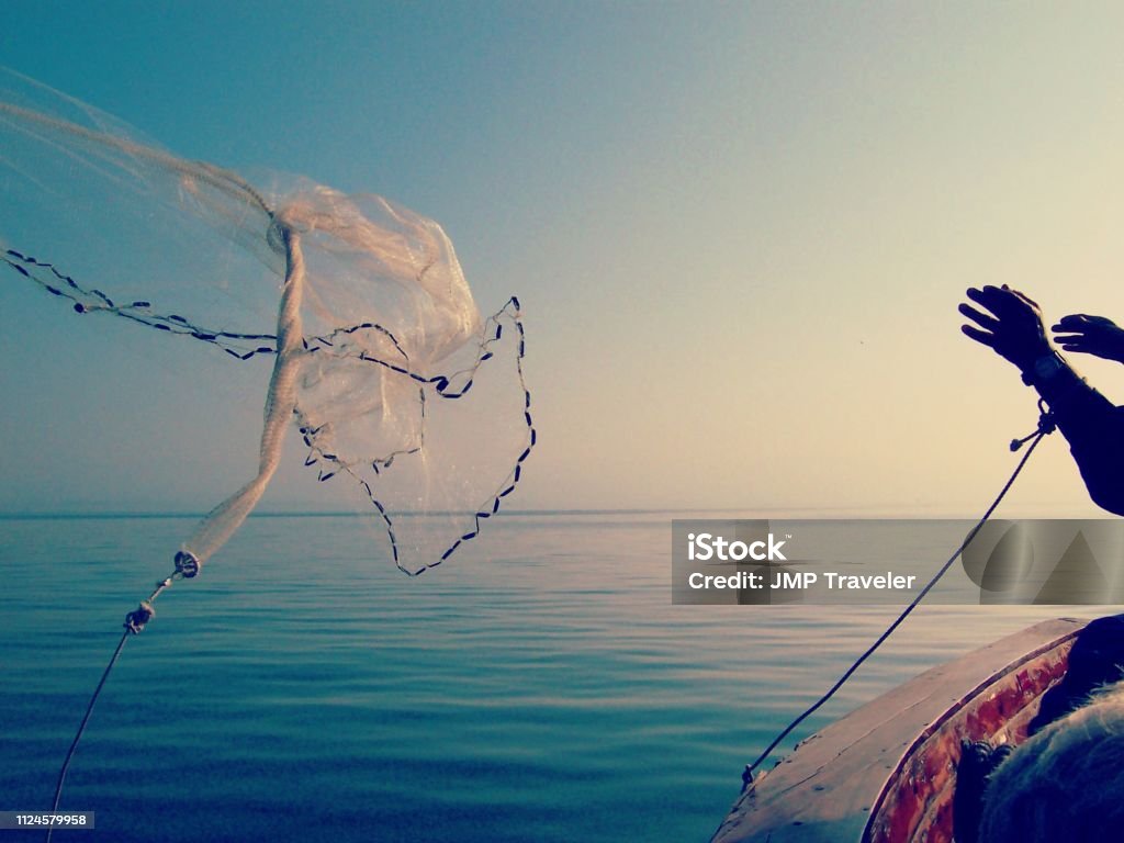 Man Throwing Fishing Net Stock Photo - Download Image Now