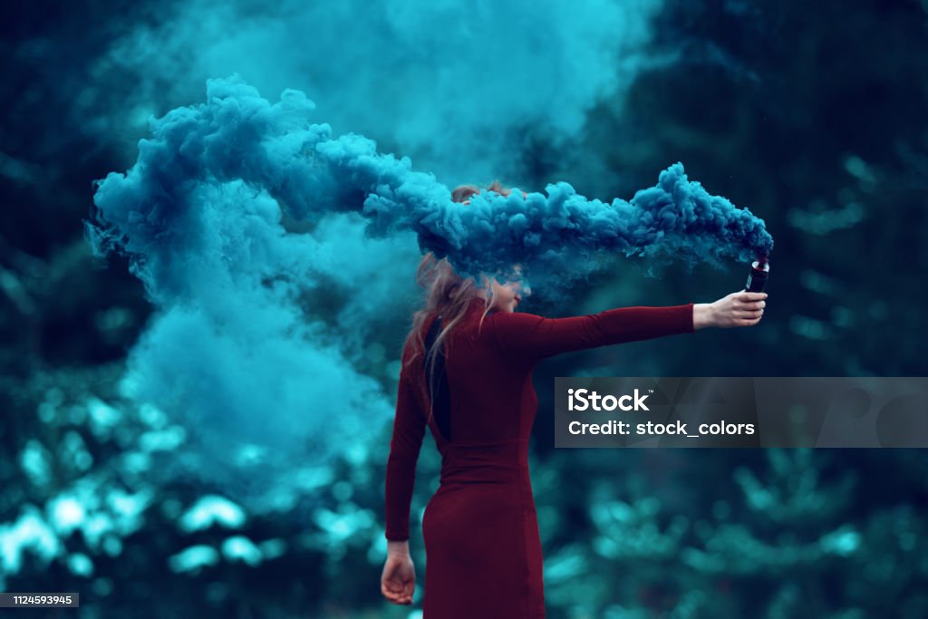 deep smoke from flaming torch side view of woman in the forest holding flaming torch. Smoke - Physical Structure Stock Photo