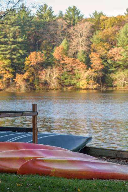 Boat rental along mirror lake in Wisconsin rental canoes and kayaks lined up along Mirror Lake in Wisconsin in fall mirror lake stock pictures, royalty-free photos & images