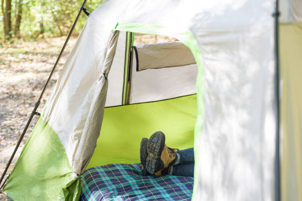 istock Person laying on cot in tent on campsite 1124596401