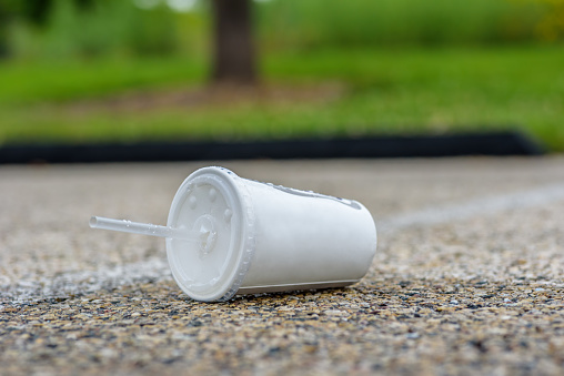 Fast food drink cup trash laying on ground