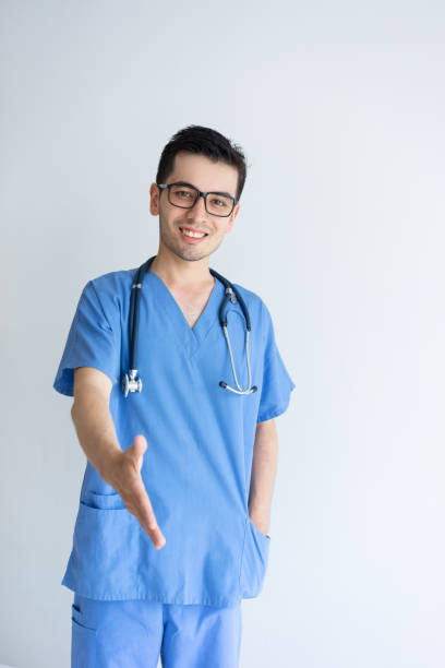 istock Smiling young male doctor extending arm for handshake 1124606244