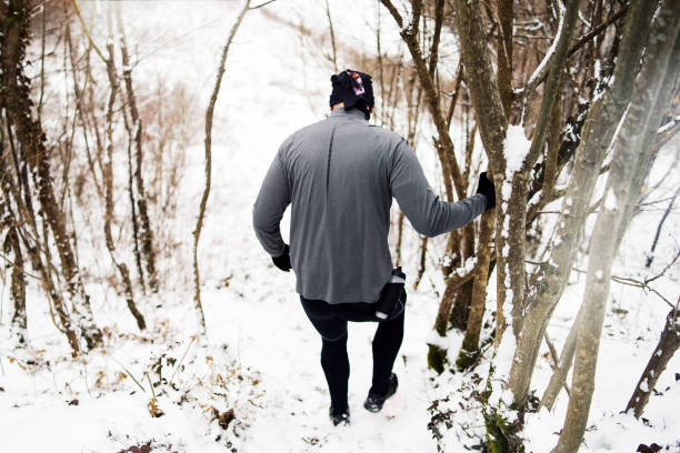 istock Man Running in nature on Snow in a Winter Day 1124606313