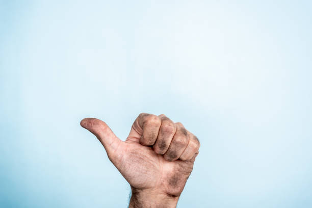 istock Overcoming adversity. One male dirty hand making thumb up gesture on blue background 1124611381