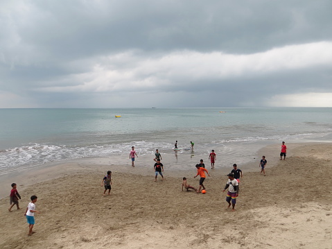 Anyer, Indonesia - June 26, 2018: Some boys play football on the sand beach of Sambolo Anyer.