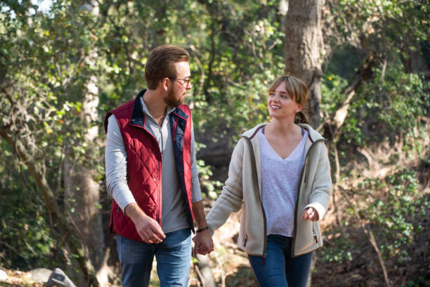istock Young Couple Walking in the Forest Holding Hands 1124617052
