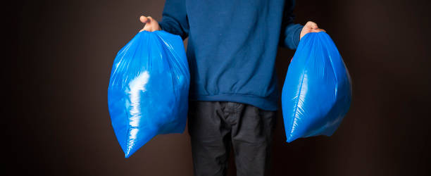 istock attractive man carry two trash bags isolated f 1124618476