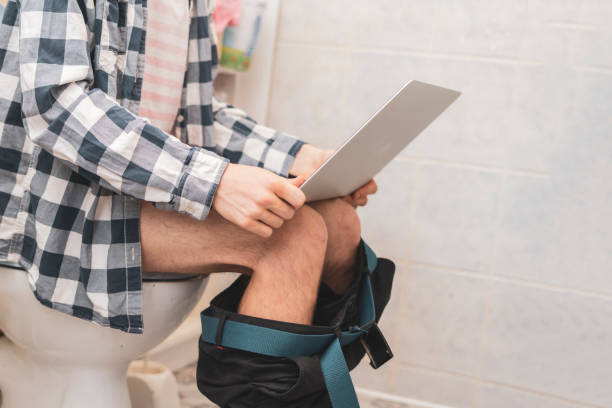 istock buisnessman sit on toilet and work with laptop in bathroom d 1124618492