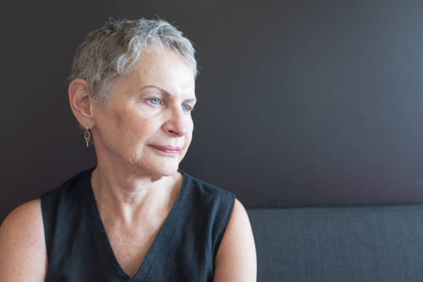 istock Older woman in black top looking away 1124626200