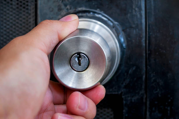 istock Hand closing a black metal door 1124627209