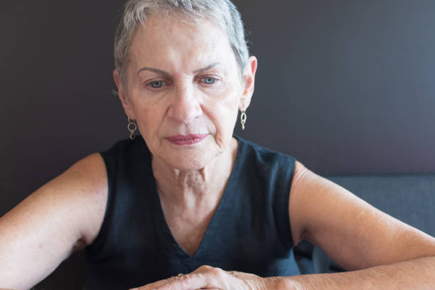 istock Older woman in black top looking pensive 1124627264