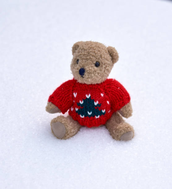 istock little teddy bear in a red sweater sits alone 1124627392