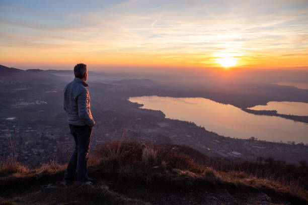 escursionista che guarda il sole all'orizzonte - dawn lake sky sunrise foto e immagini stock
