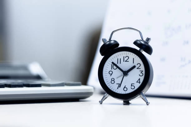 istock Alarm clock  and  Calendar with calculating  on desk table . 1124630112