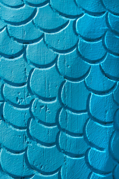 Close up of blue painted scale shapes.