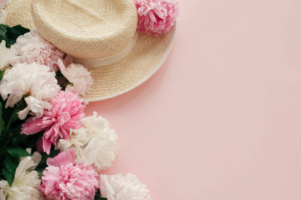 istock Straw hat with white and pink peonies on pastel pink paper, flat lay.  Hello spring image with copy space. Summer vacation concept. International Women's Day. Happy mothers day 1124634618