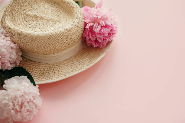 istock Straw hat with white and pink peonies on pastel pink paper. Hello spring, creative image with copy space. Summer vacation concept. International Women's Day. Happy mothers day 1124635437