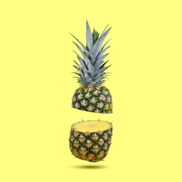 Fresh tropical fruit pineapple. Fresh tropical fruit pineapple cut in half on yellow background. halved stock pictures, royalty-free photos & images