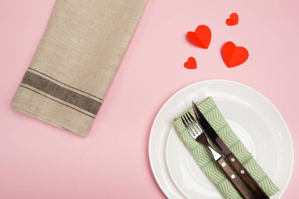 istock Festive table setting for Valentine's Day with fork, knife,  hearts on a red background. Top view. - Image 1124639748