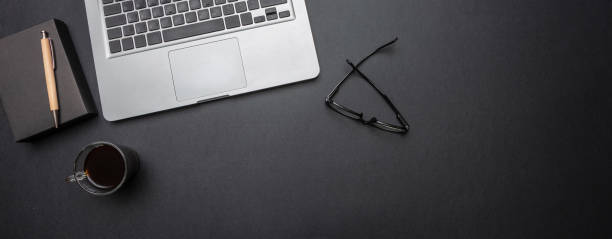 istock Computer laptop and mobile phone on black color office desk, banner 1124643920
