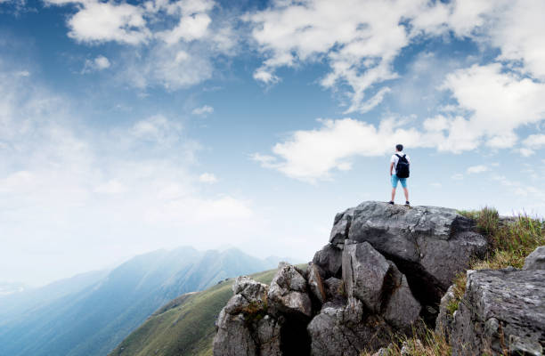 istock Man backpacker on the top of mountain 1124644295