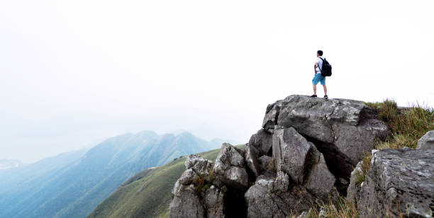 istock Man backpacker on the top of mountain 1124644383