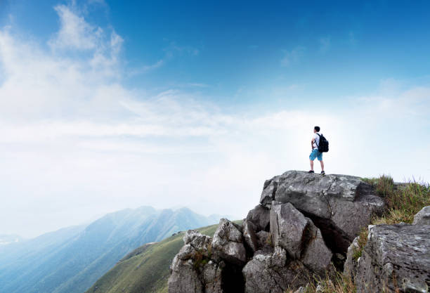 istock Man backpacker on the top of mountain 1124644435