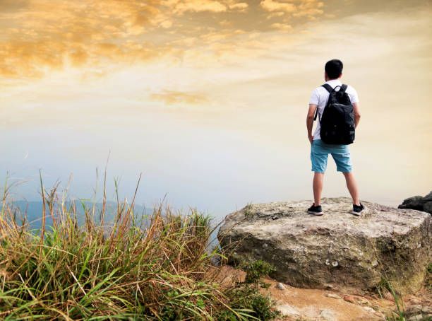 istock Man backpacker on the top of mountain at sunset 1124644437