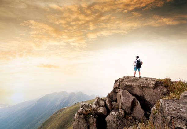 istock Man backpacker on the top of mountain at sunset 1124645060
