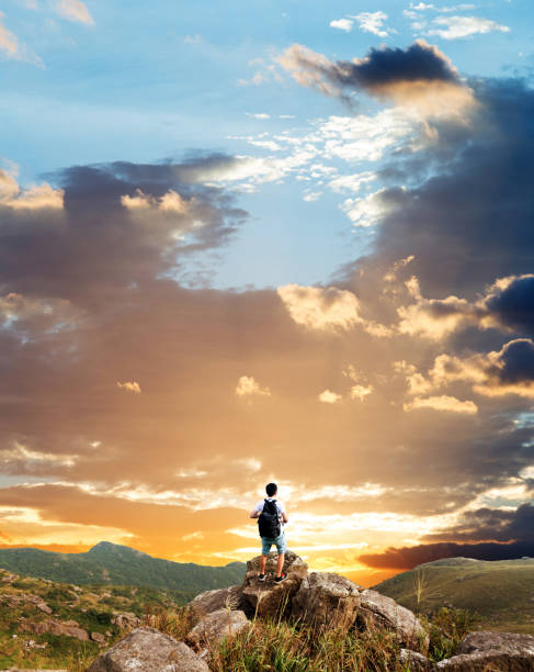 Man backpacker on the top of mountain at sunset.