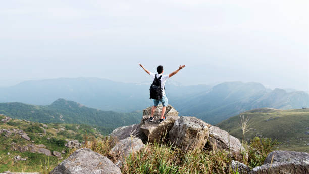 istock Man backpacker on the top of mountain 1124645156