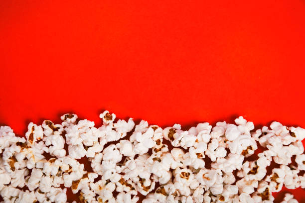 istock Tasty salted popcorn isolated on red background 1124645281