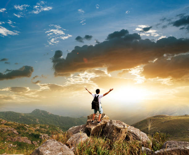 istock Man backpacker on the top of mountain at sunset 1124645378