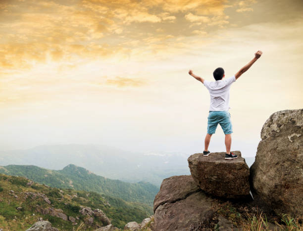istock Man on the top of mountain at sunset 1124645487