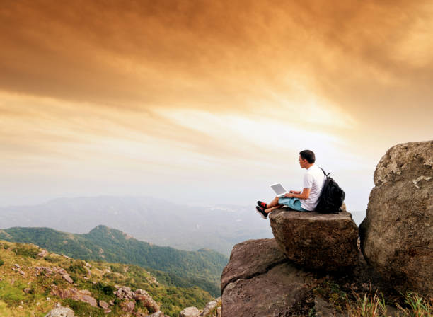istock Man using laptop on top of mountain 1124646374