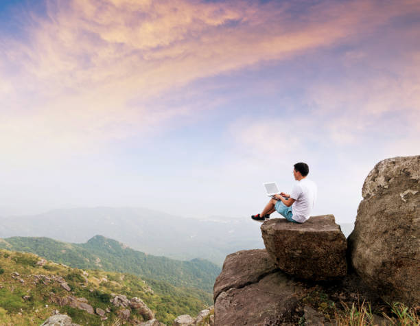 istock Man using laptop on top of mountain 1124646469