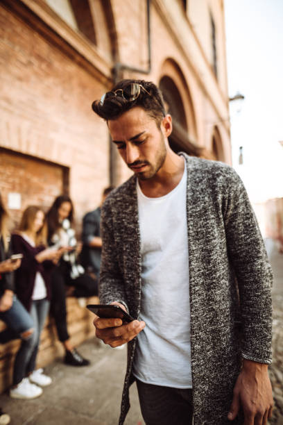 istock man standing out from the crowd on the phone 1124646474