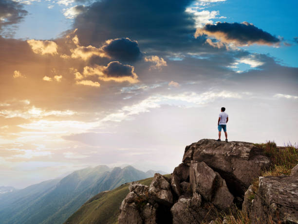 istock Man standing on the top of mountain at sunset 1124646862